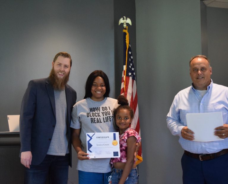 Group of people smiling and holding certificates.