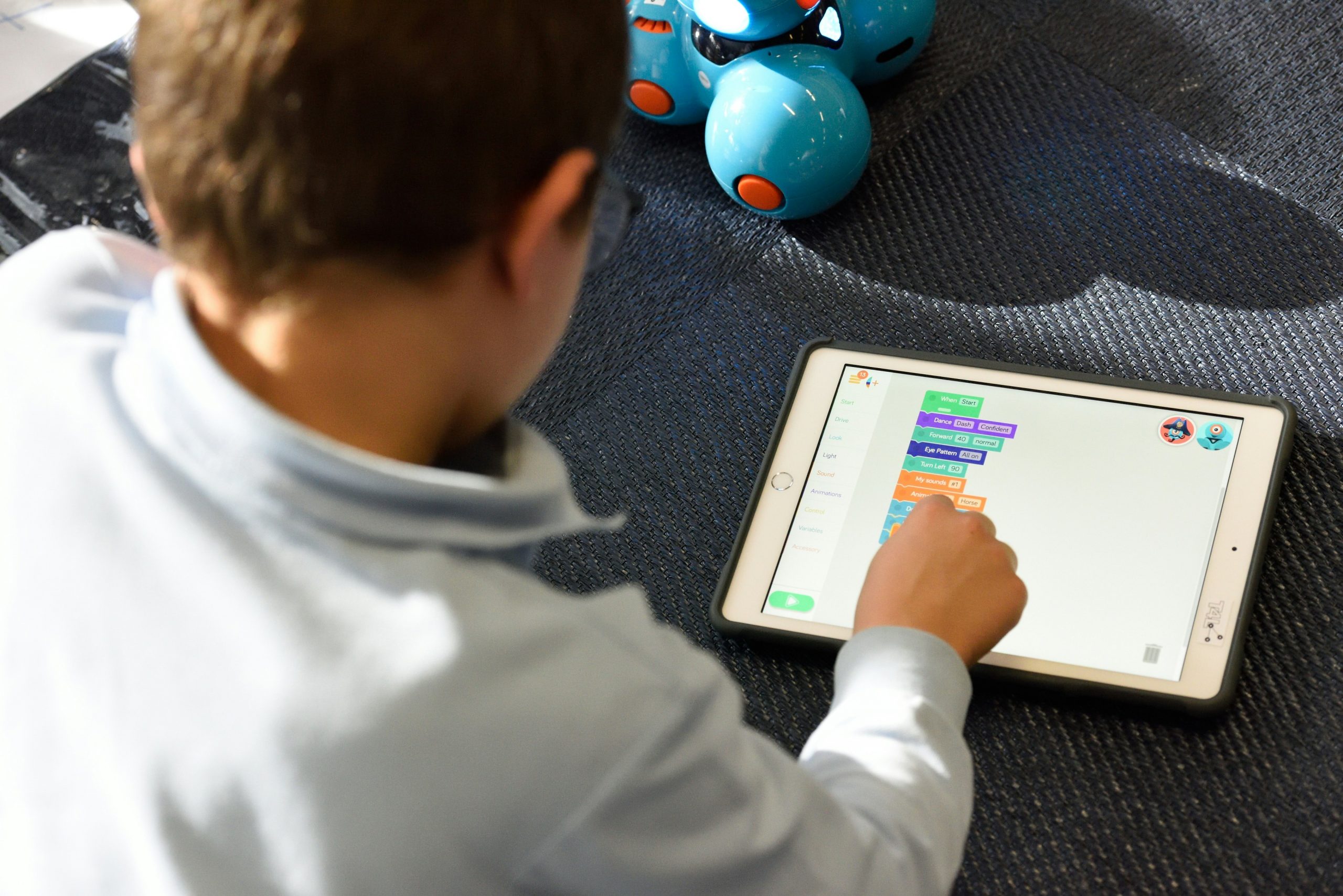 A child using a tablet with an education app on the screen.