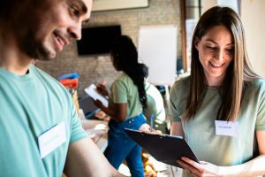 People smiling and holding a clipboard