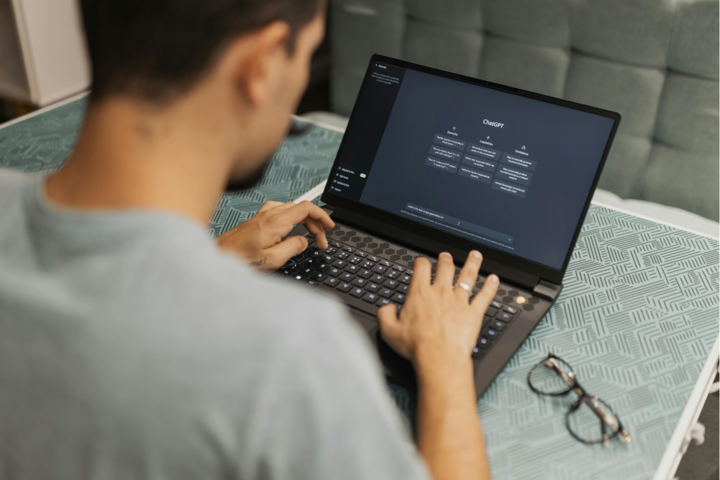 Person typing on a laptop with ChatGPT open on the screen.