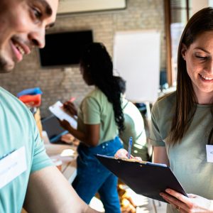 Volunteer-Stock-scaled.jpg People smiling and holding a clipboard